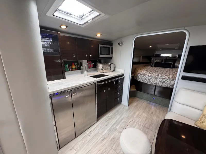 Slide: The Image of The interior of a 2016 Formula 40 Performance Cruiser features a modern kitchen with stainless steel appliances and a cozy bedroom. - 22