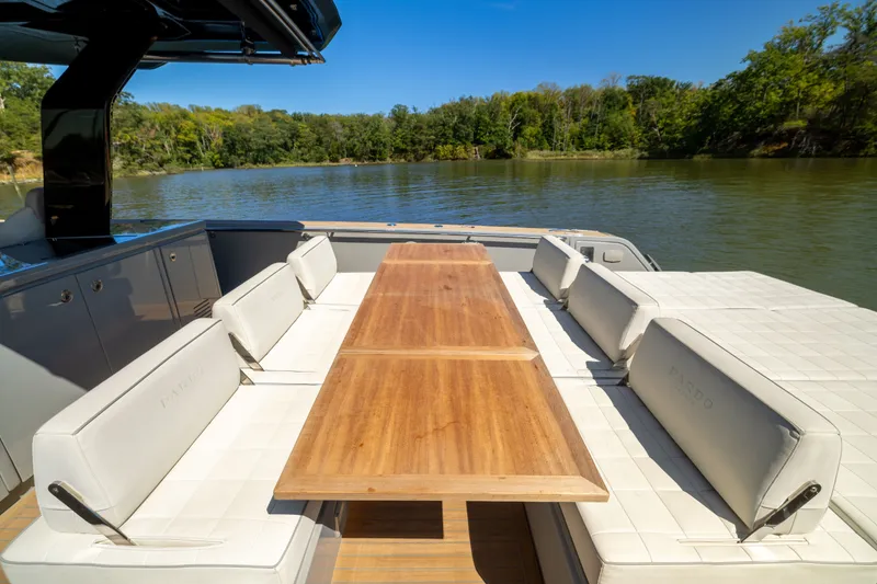 Slide: The Image of 2023 Pardo Yachts 43 luxury deck with elegant seating and wooden table, surrounded by serene water. - 44