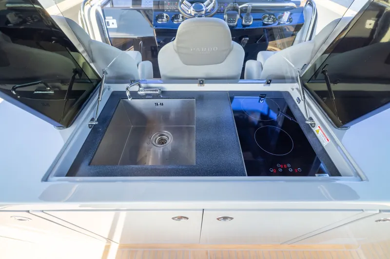Slide: The Image of Modern kitchen area on 2023 Pardo Yachts 43, featuring sink and electric cooktop. - 38