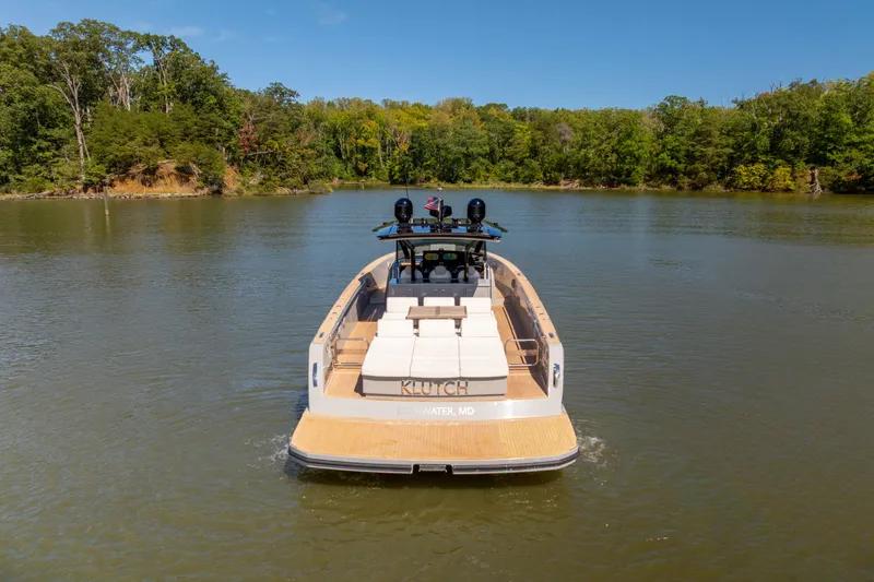 Slide: The Image of 2023 Pardo Yachts 43 cruising on a serene lake with lush green shoreline. - 13