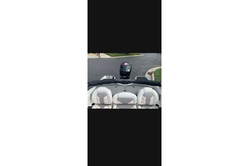 Slide: The Image of 2021 Nitro Z19 boat interior with seats and motor, parked on pavement. - 4