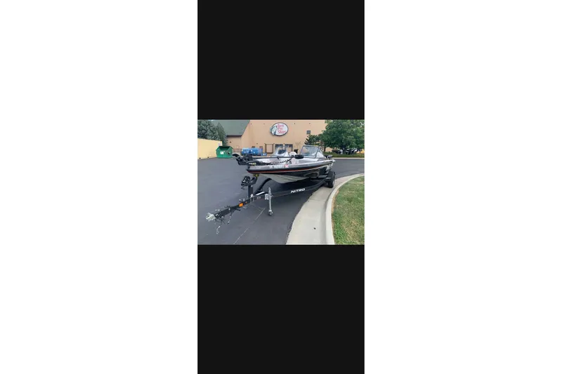 The Image of 2021 Nitro Z19 boat parked on pavement near a building. - 1