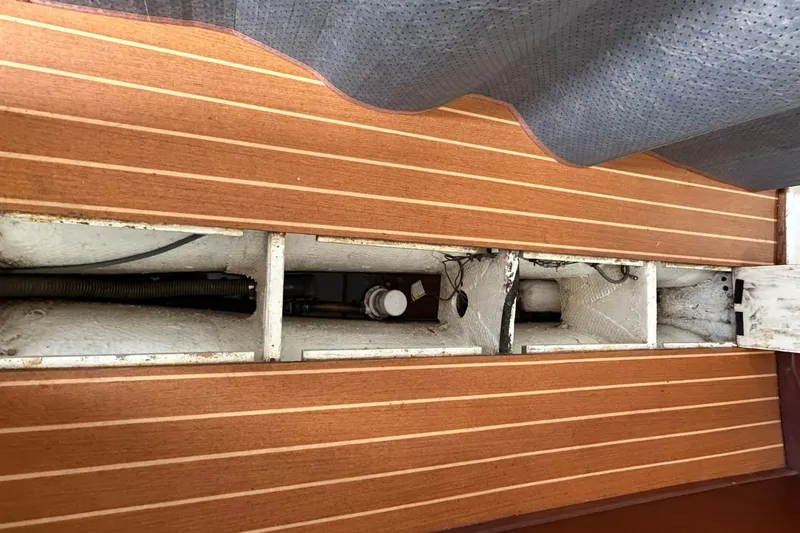 Slide: The Image of Interior view of a 1980 Tartan 33 sailboat, showcasing wooden flooring and mechanical components. - 47