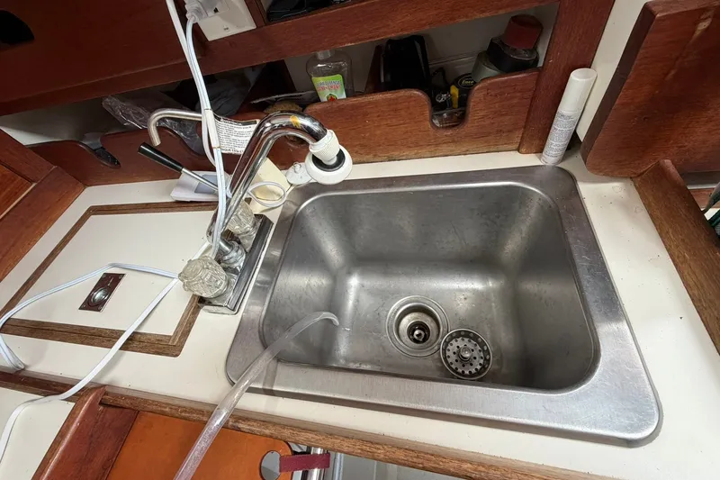 Slide: The Image of 1980 Tartan 33 yacht kitchen sink with wooden trim and faucet. - 31