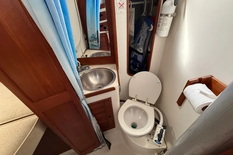 Slide: The Image of Compact bathroom in a 1980 Tartan 33 sailboat with toilet, sink, and storage. - 40
