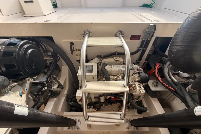 Slide: The Image of Engine compartment of a 2003 Cabo 35 Express boat with visible machinery and ladder. - 46