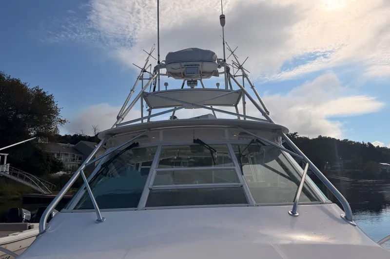 Slide: The Image of 2003 Cabo 35 Express boat docked under a partly cloudy sky. - 11