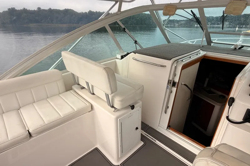 Slide: The Image of 2003 Cabo 35 Express boat interior with white seating and cabin entrance. - 30