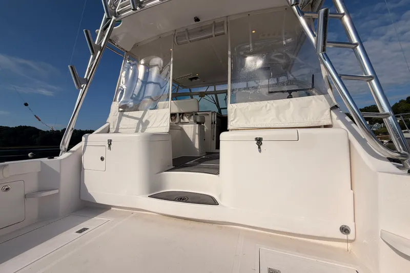Slide: The Image of 2003 Cabo 35 Express boat deck with seating and storage under clear skies. - 17