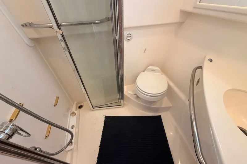 Slide: The Image of Compact bathroom in a 2003 Cabo 35 Express boat with shower, toilet, and sink. - 37