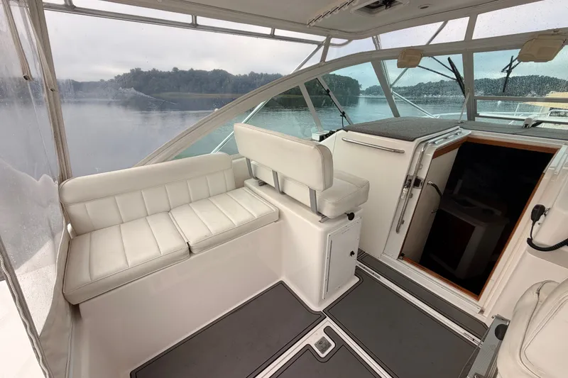 Slide: The Image of 2003 Cabo 35 Express boat interior with white seating and cabin entrance. - 27
