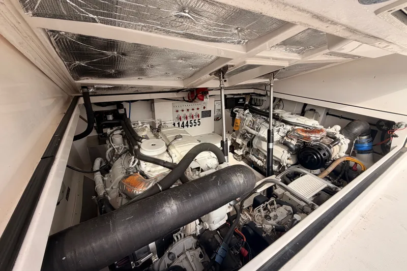 Slide: The Image of Engine room of a 2003 Cabo 35 Express boat, showcasing dual engines and mechanical components. - 52