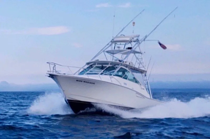Slide: The Image of 2003 Cabo 35 Express boat cruising on open water, creating waves. - 3