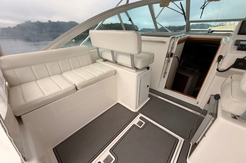 Slide: The Image of 2003 Cabo 35 Express boat interior with white seating and helm area. - 28