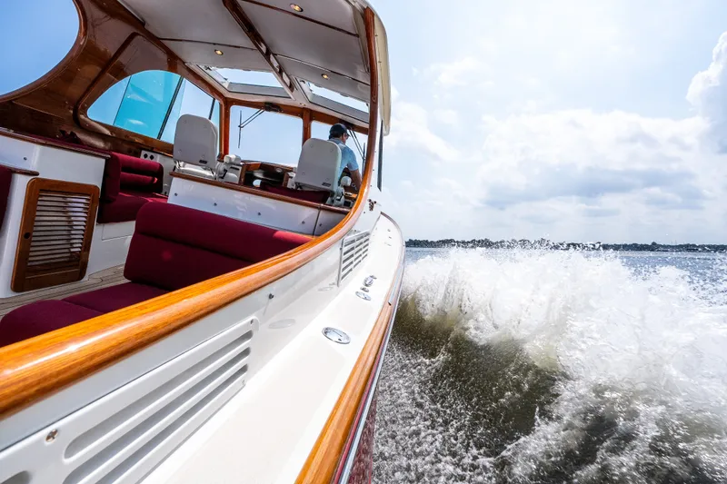 Slide: The Image of 2020 Hinckley Picnic Boat 37 MKIII cruising on water, interior view with red seating. - 32