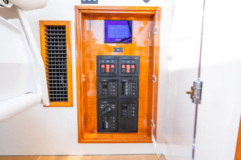 Slide: The Image of Electrical control panel on 2020 Hinckley Picnic Boat 37 MKIII, featuring switches and display. - 37