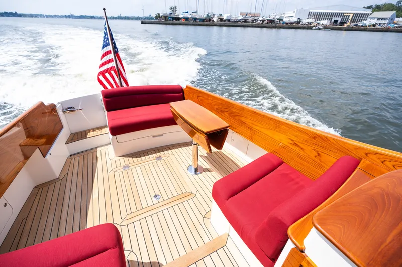 Slide: The Image of Hinckley Picnic Boat 37 MKIII, 2020 model, with red seating and wooden deck, cruising on water. - 16