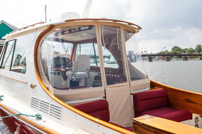 Slide: The Image of 2020 Hinckley Picnic Boat 37 MKIII with enclosed cockpit, docked by a scenic waterfront. - 54