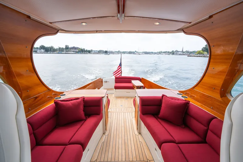 Slide: The Image of Luxurious 2020 Hinckley Picnic Boat 37 MKIII interior with red seating and scenic water view. - 13