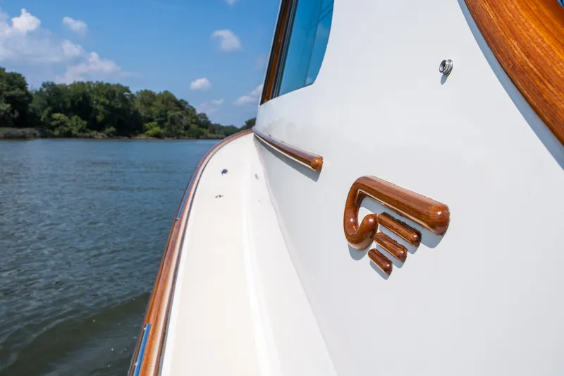 Slide: The Image of 2020 Hinckley Picnic Boat 37 MKIII on calm water, showcasing elegant wooden details. - 31