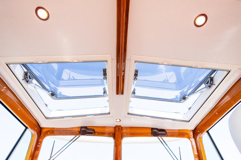Slide: The Image of 2020 Hinckley Picnic Boat 37 MKIII interior skylights with wooden trim and recessed lighting. - 28