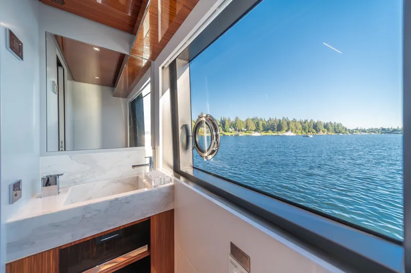 Slide: The Image of Luxurious bathroom view on 2021 Riva 110' Dolcevita yacht, overlooking serene waters and lush shoreline. - 63