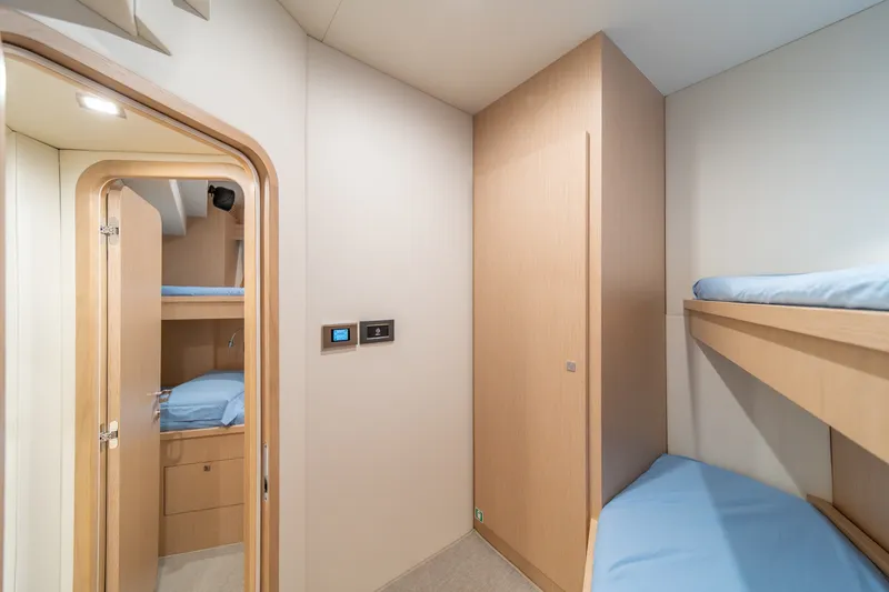Slide: The Image of Interior of 2021 Riva 110' Dolcevita yacht with modern bunk beds and light wood finish. - 84