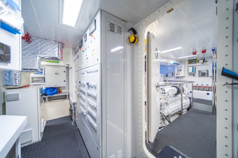 Slide: The Image of Engine room of 2021 Riva 110' Dolcevita yacht, featuring advanced control panels and machinery. - 94