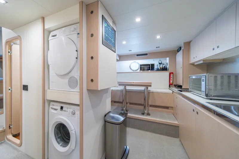 Slide: The Image of Modern laundry and kitchen area on 2021 Riva 110' Dolcevita yacht, featuring appliances and sleek design. - 80