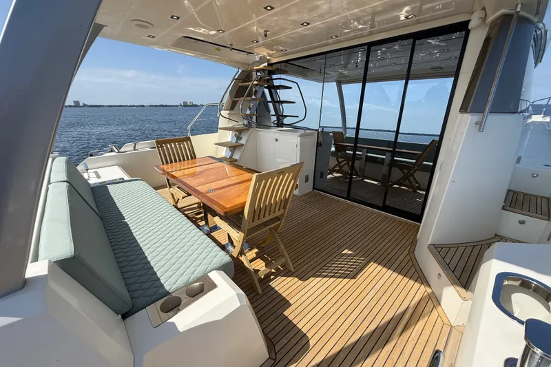 Slide: The Image of Luxurious 2017 Prestige 630 yacht deck with seating and dining area, overlooking serene waters. - 16