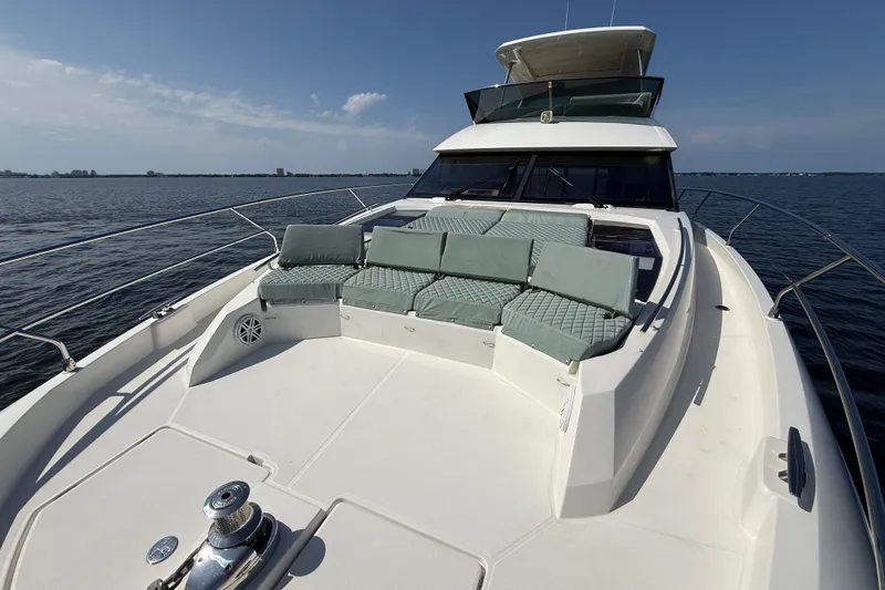 Slide: The Image of Luxurious 2017 Prestige 630 yacht with spacious deck and cushioned seating on open water. - 13