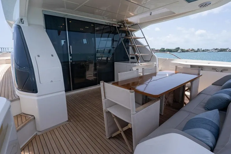 Slide: The Image of Outdoor seating area on 2020 Ferretti Yachts 670, featuring a wooden table and cushioned chairs. - 21