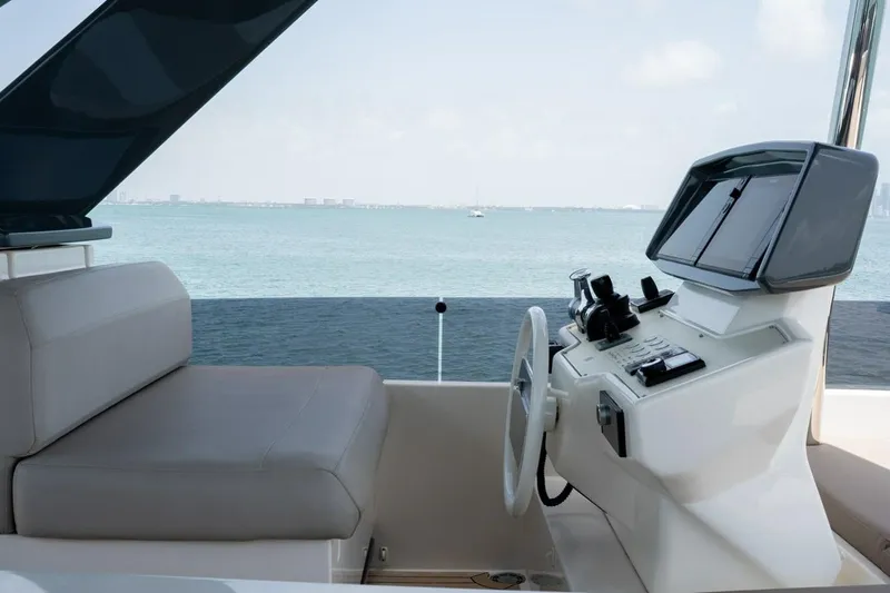 Slide: The Image of Helm of 2020 Ferretti Yachts 670 with ocean view, featuring modern controls and seating. - 16