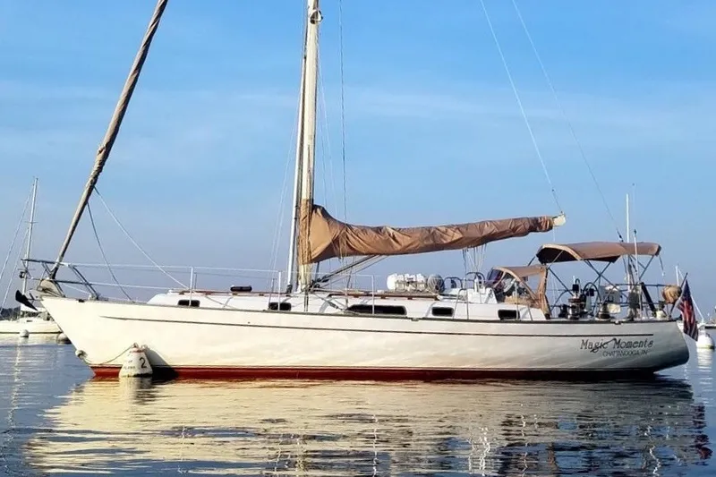 The Image of Sailboat "Magic Moments," Passport 41 model, 1988, anchored on calm water under clear sky. - 0