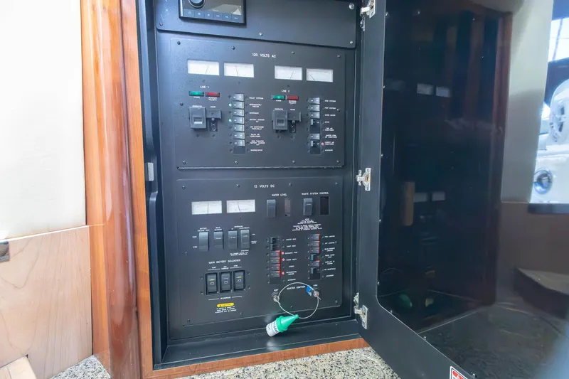 Slide: The Image of Electrical panel inside a 2005 Sea Ray 420 Sundancer yacht, showcasing switches and controls. - 26