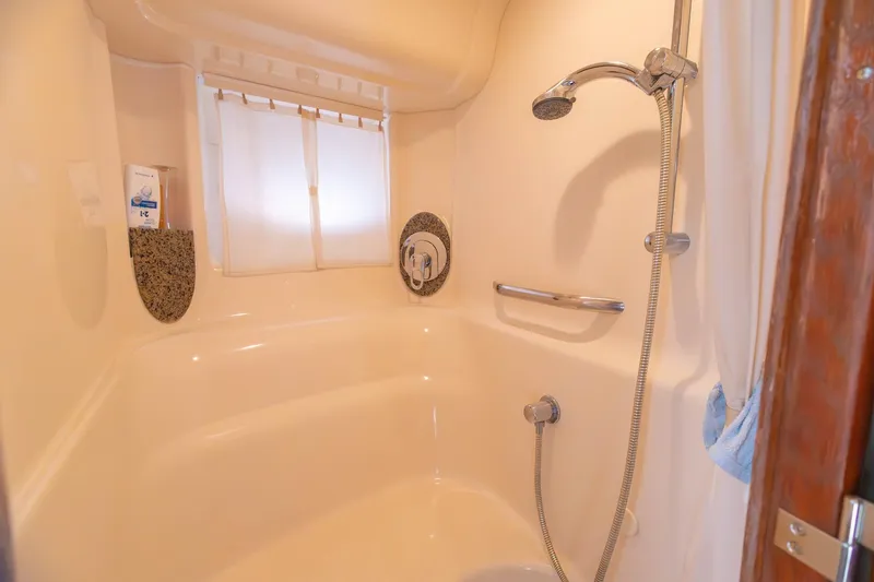 Slide: The Image of Shower area in 2005 Sea Ray 420 Sundancer yacht, featuring modern fixtures and curtain. - 17