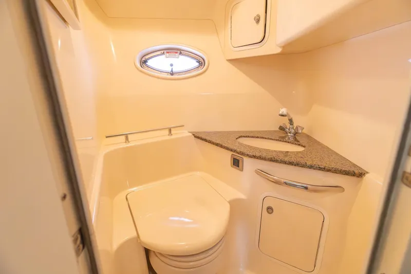 Slide: The Image of 2005 Sea Ray 420 Sundancer bathroom with sink, toilet, and porthole window. - 23