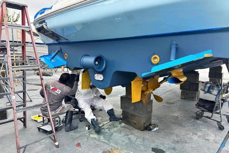Slide: The Image of Workers maintaining a 2005 Sea Ray 420 Sundancer boat hull in a shipyard. - 41