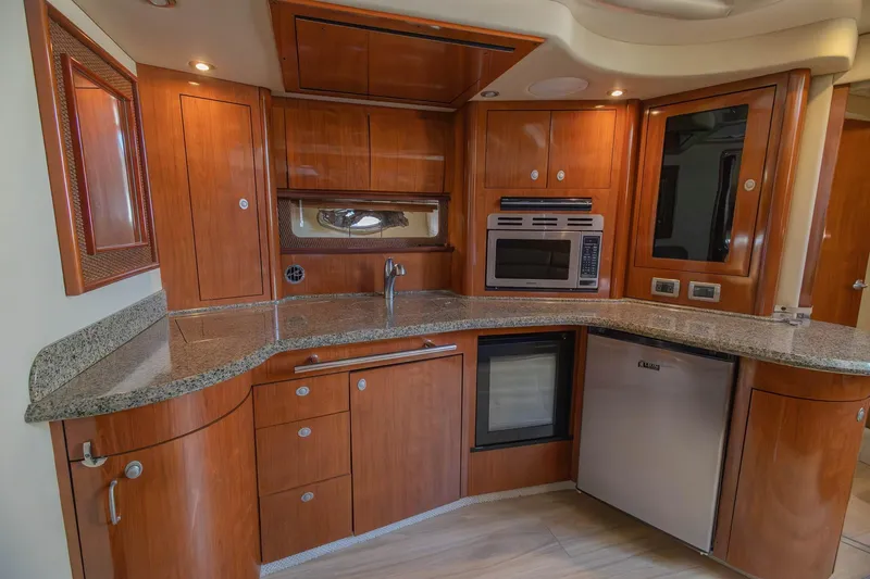 Slide: The Image of Luxurious 2005 Sea Ray 420 Sundancer yacht kitchen with wood cabinetry and modern appliances. - 19