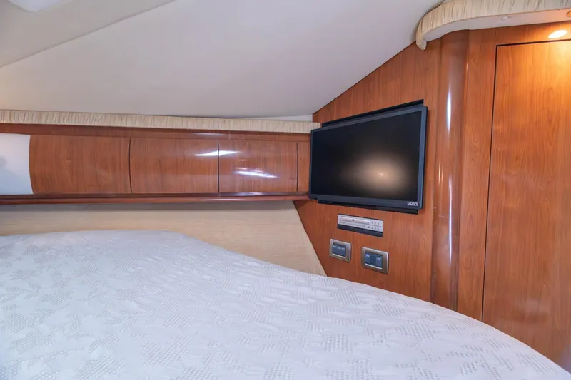 Slide: The Image of Luxurious cabin interior of 2005 Sea Ray 420 Sundancer with TV and wood paneling. - 15