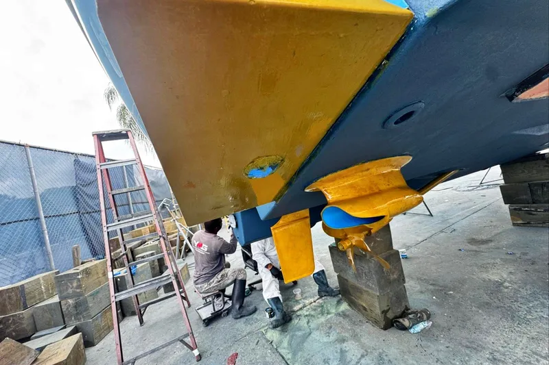 Slide: The Image of Workers repairing the hull of a 2005 Sea Ray 420 Sundancer boat. - 40