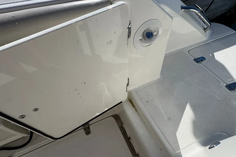 Slide: The Image of 2021 Boston Whaler 250 Outrage boat interior, featuring a clean white deck and storage compartment. - 14