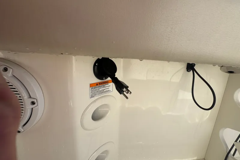 Slide: The Image of 2021 Boston Whaler 250 Outrage interior with power outlet and warning label. - 20