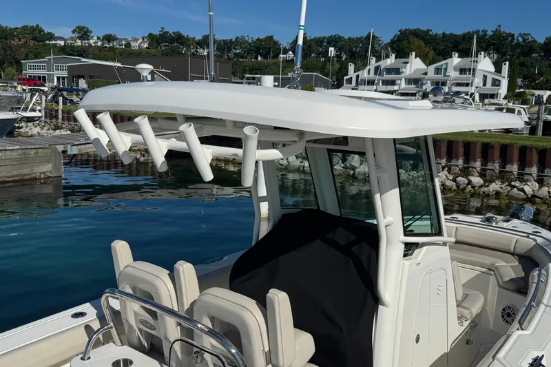 Slide: The Image of 2021 Boston Whaler 250 Outrage boat docked in a marina with modern architecture. - 30