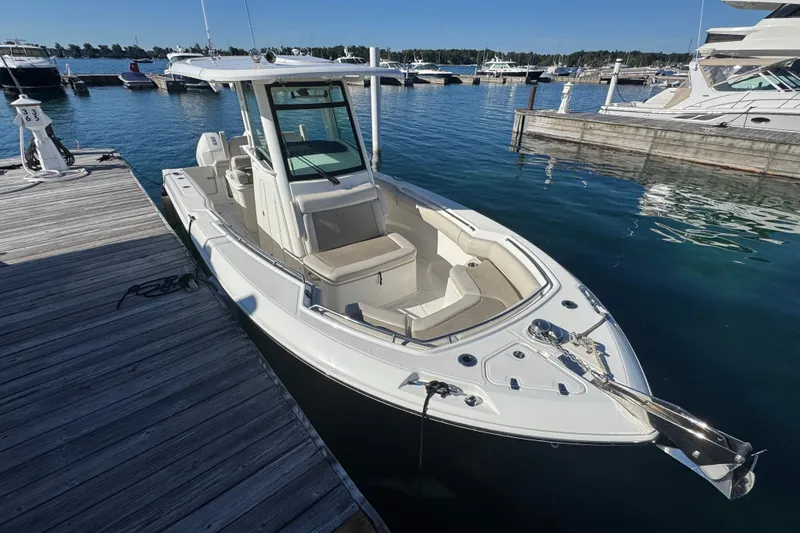 Slide: The Image of 2021 Boston Whaler 250 Outrage docked at marina, showcasing sleek design and spacious seating. - 3