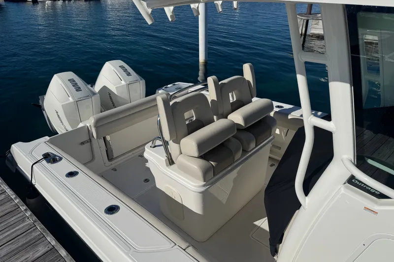 Slide: The Image of 2021 Boston Whaler 250 Outrage boat with dual engines docked by the water. - 4