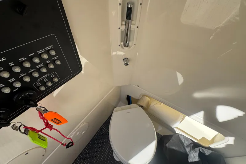 Slide: The Image of Interior of a 2021 Boston Whaler 250 Outrage boat featuring a compact marine toilet. - 22