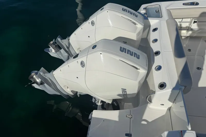 Slide: The Image of 2021 Boston Whaler 250 Outrage with dual outboard engines on calm water. - 6