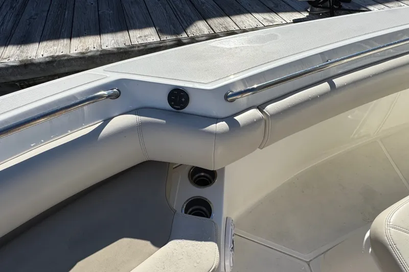 Slide: The Image of 2021 Boston Whaler 250 Outrage boat interior with cushioned seating and stainless steel railings. - 29