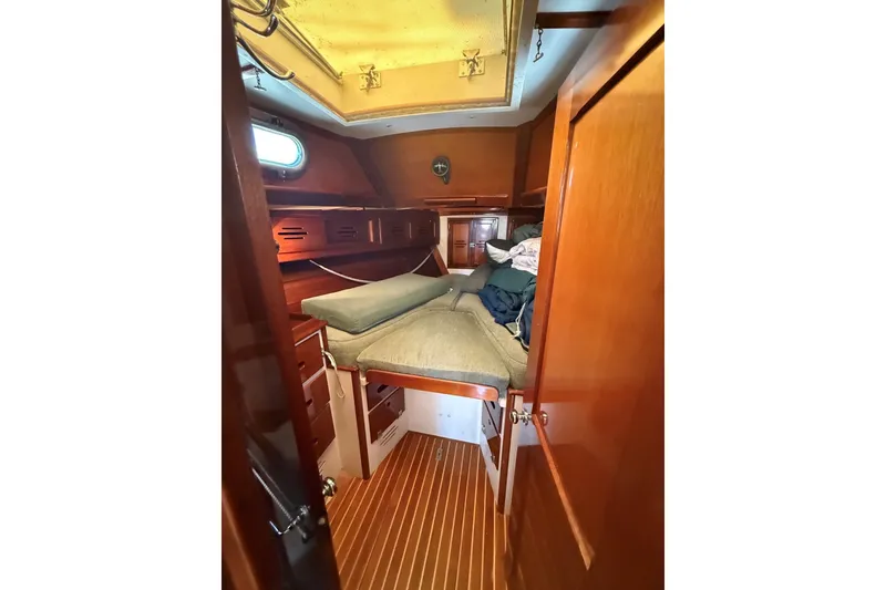 Slide: The Image of Cabin interior of 1984 Hinckley Sou'wester 42 sailboat with wooden finish and cozy bedding. - 48